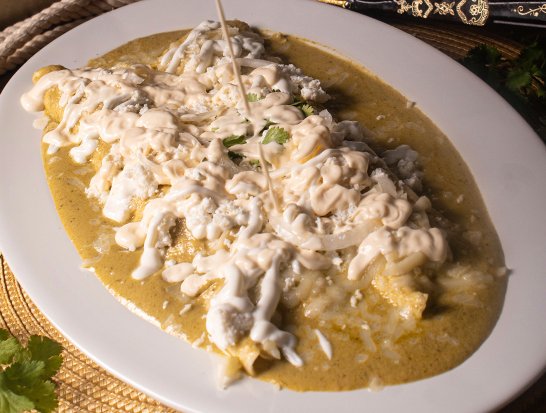 Enchiladas Suizas - Four tortillas filled with chicken or fresh cheese, topped with creamy poblano sauce